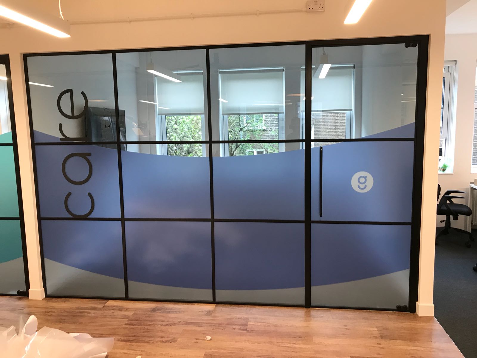 Branded vinyl graphics applied to office glass partitions by UK Install